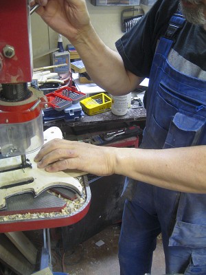 I cut the pickguard from the blank sheet with a band saw and fastened it to the template with double-sided tape. Making pickup holes in the pickguard I drilled with a forstner bit holes big enough for a flush trim router bit.