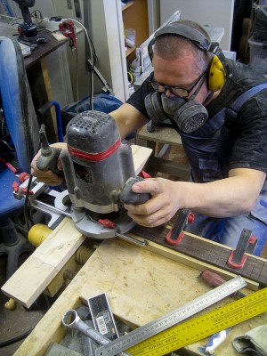 I have constructed a straight-edge guide for routing Fender type nut slots. Using a 3 mm straight router bit here.