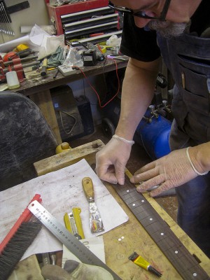 Gluing fret markers into place.