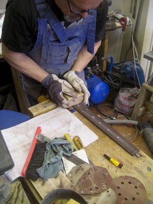 Sanding fret markers flush with the fretboard.