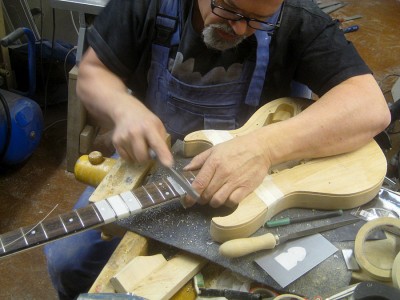 I marked the problem frets with a felt tip pen, levelled the frets with a triangular file first and rounded them off with a crowning file.