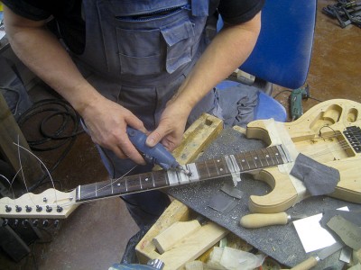 After sanding the filed-down and crowned frets with 800, 1200 and 2000 grit papers I polished them with polishing wax and a felt buffer.