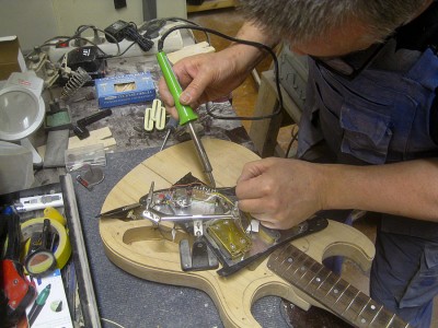 The electronics getting assembled here. I shielded the pickguard with self-adhesive &quot;2 wide aluminium tape, installed the pickups, the pickup selector switch and the pots.