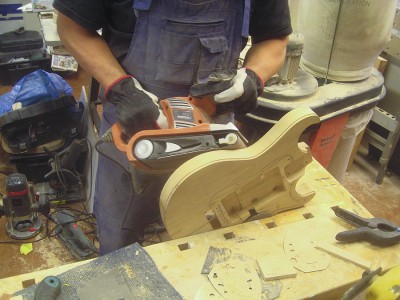 I disassembled the guitar and returned to woodwork. I cut a body back contour with a belt sander before fine sanding everything with plane and detail sanders and by hand prior to the paint job.