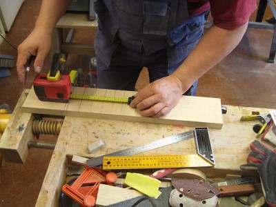 Measuring fret distances with a digital measuring tape.