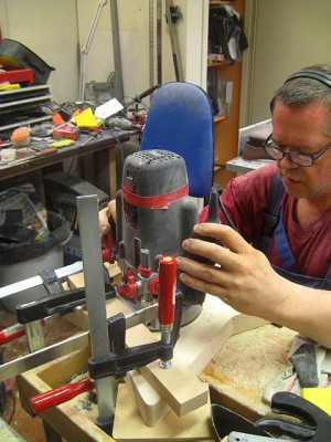 The hardtail bridge is the string-thru-body type. I'm using my own string retainer made of a piece of scrap steel bar and routing the retainer cavity here.