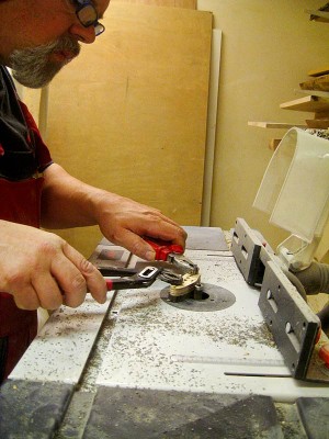 Trimming the flatwork edges here. I prefer to keep my fingers away from the spinning router bit and use pliers to hold the steel bars securing the forbon sheet.