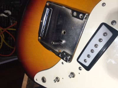 This is how the bridge looks on the guitar. You can see an arm comes up that a tremolo bar would attach to (no tremolo bar included with guitar).