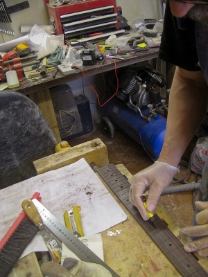 Applying CA glue to fret marker pits.